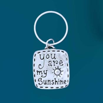 an image of a rectangle shaped pewter keychain that says You Are My Sunshin and has a little sun