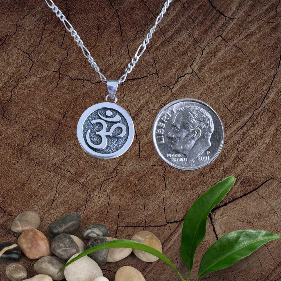 an image of a round Sterling Silver Om Disc Pendant next to a dime