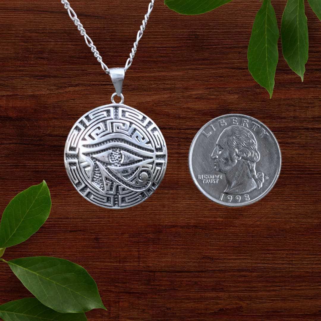 an image of an Eye of Horus Sterling Silver Pendant next to a quarter