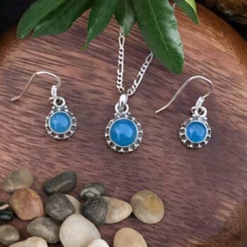 an image of a Sterling Silver and Blue Chalcedony Pendant and Earrings Set with a dainty round pendant and matching slightly smaller round dangle earrings.