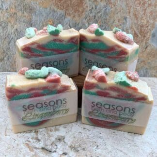 an image of four bars of All Natural Lingonberry Soap with soft red and green colors on cream