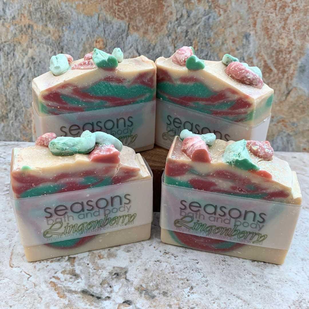 an image of four bars of All Natural Lingonberry Soap with soft red and green colors on cream