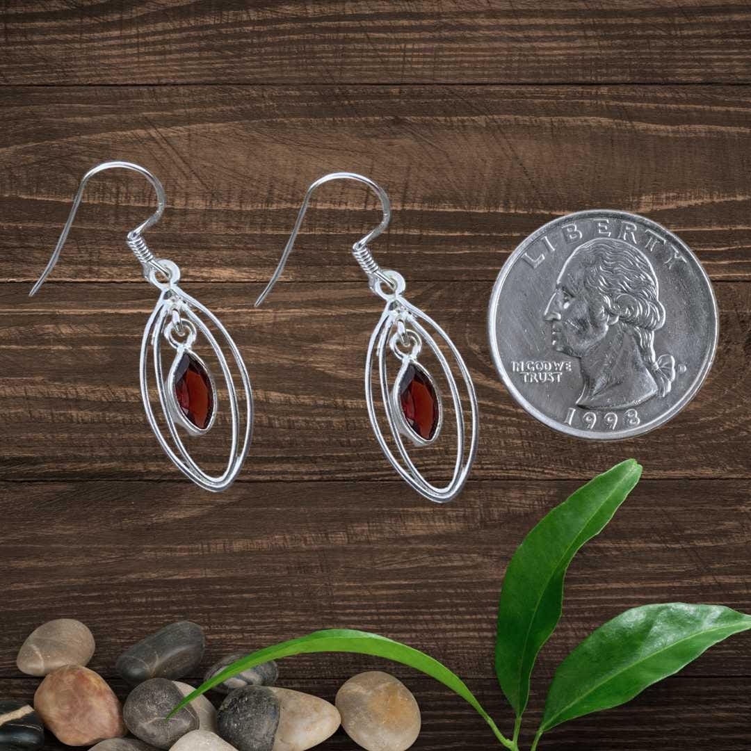 an image of a pair of dangling Open Marquise Sterling Silver Garnet Earrings next to a quarter