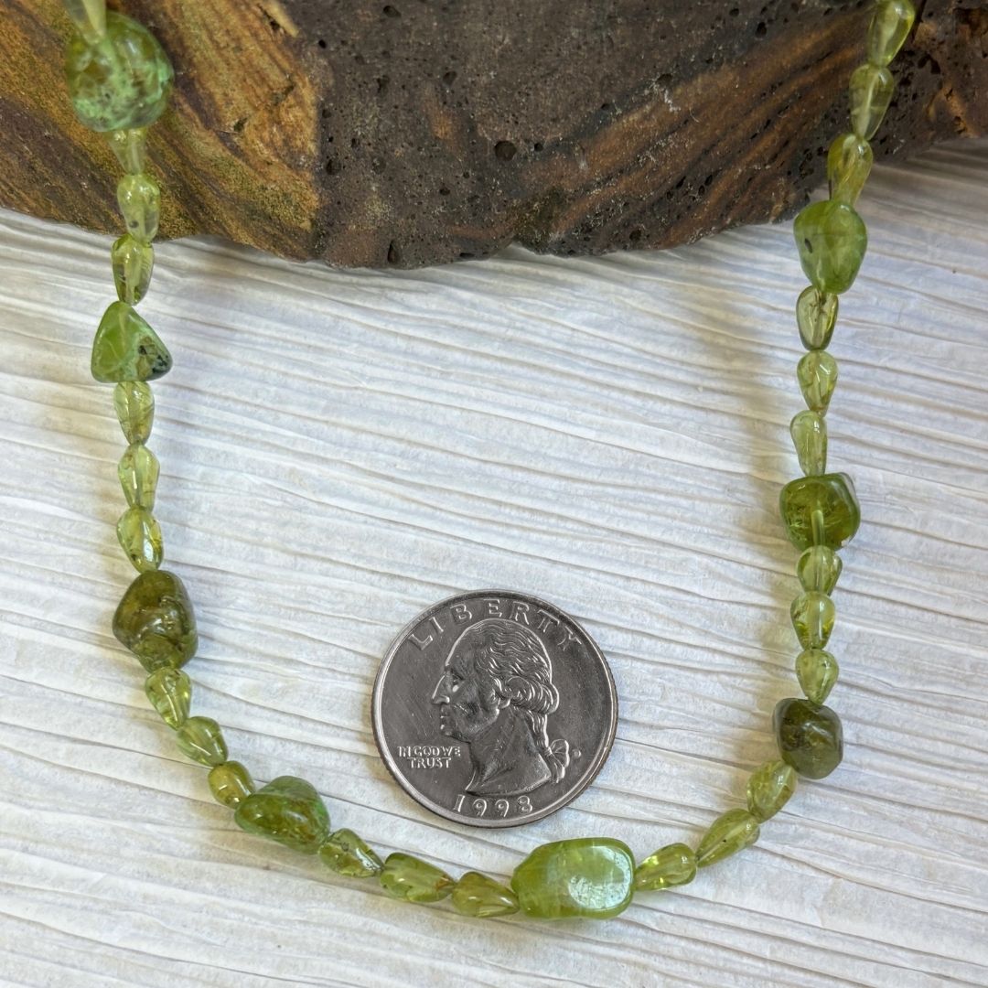 an image of our Peridot Nugget and Teardrop Beads Necklace next to a quarter