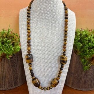 an image of a beaded tiger's eye gemstone necklace featuring four large barrel shaped beads with smaller round beads.