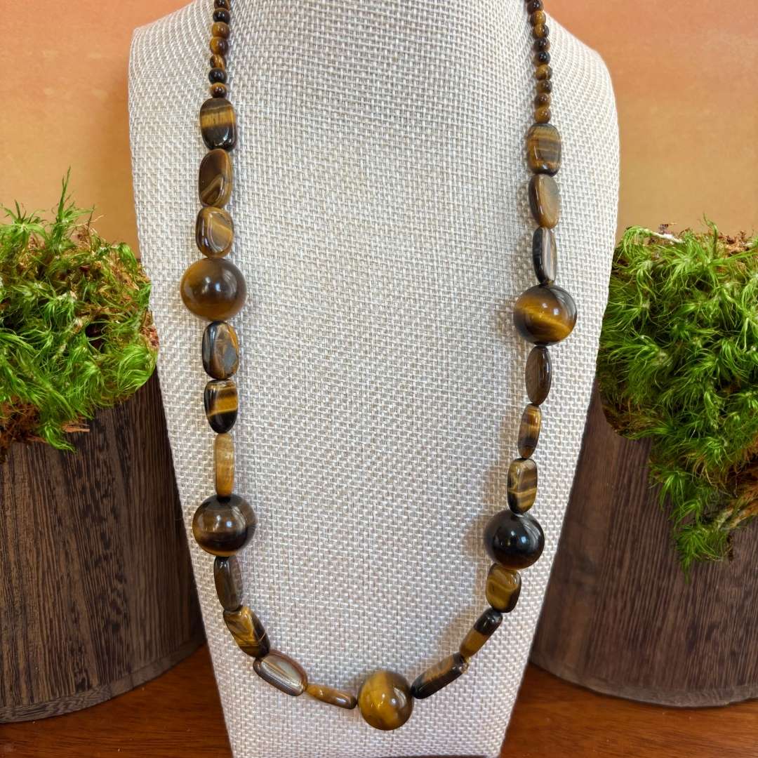 an image of a tiger's eye gemstone beaded necklace featuring large round beads mixed with a variety of other shapes.