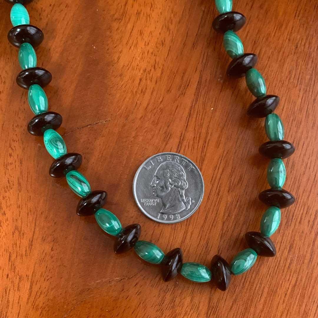 an image of a Malachite and Black Onyx Beaded Necklace with malachite barrel beads and black onyx saucer beads and next to a quarter