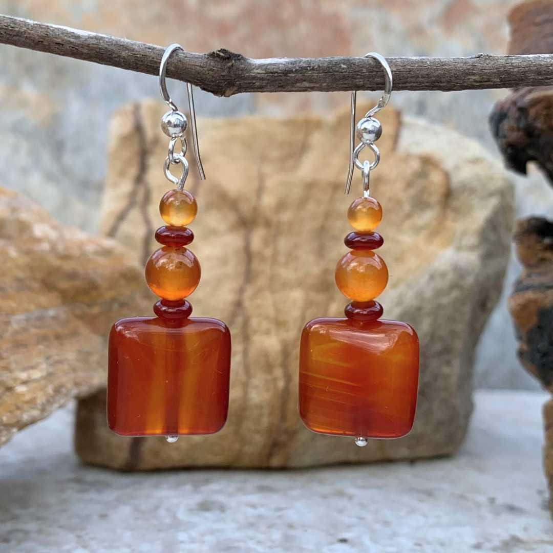 an image of a pair of Square Carnelian Mixed Beaded Earrings with a square carnelian gemstone at the bottom and alternating small rondelle and round beads going up above it.