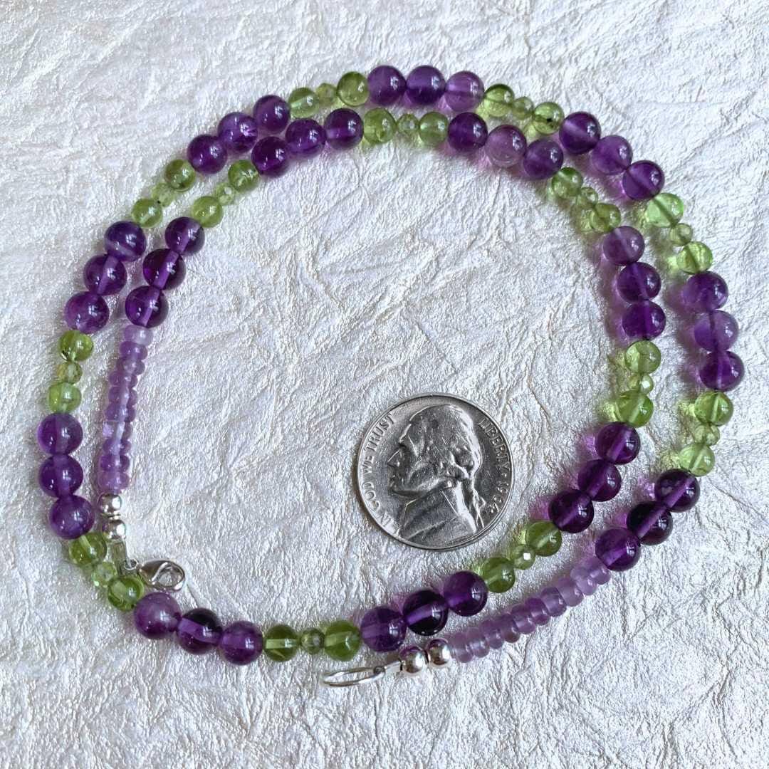 an image of a Amethyst and Peridot Beaded Necklace in a circle next to a nickel