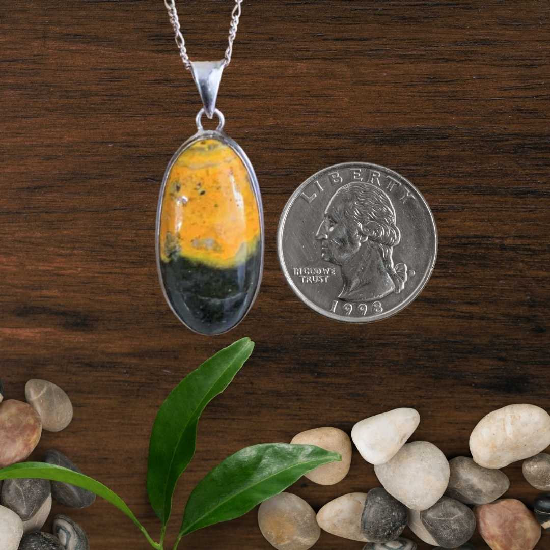 an image of a Sterling Silver and Oval Bumblebee Jasper Pendant next to a quarter