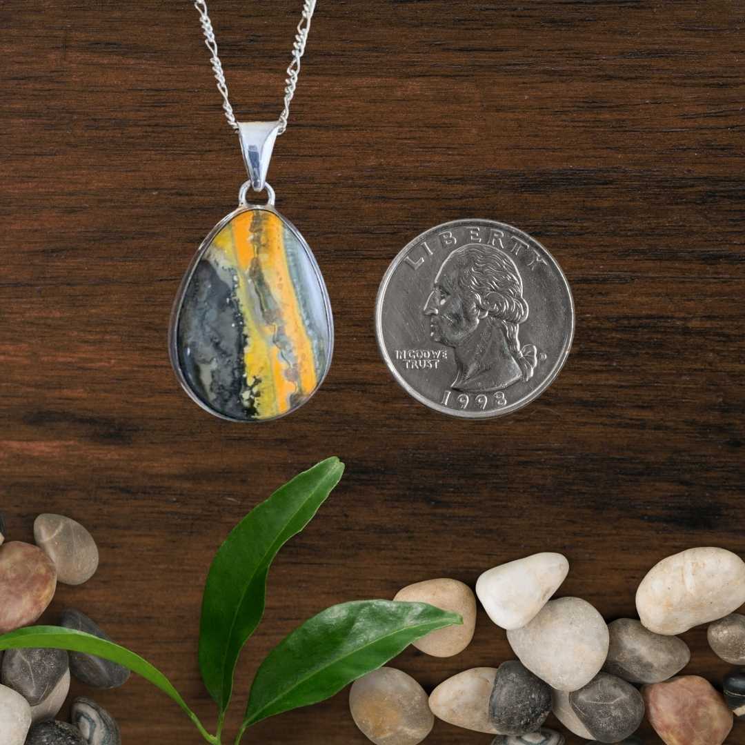 an image of a Pear Shaped Bumblebee Jasper and Sterling Silver Pendant next to a quarter