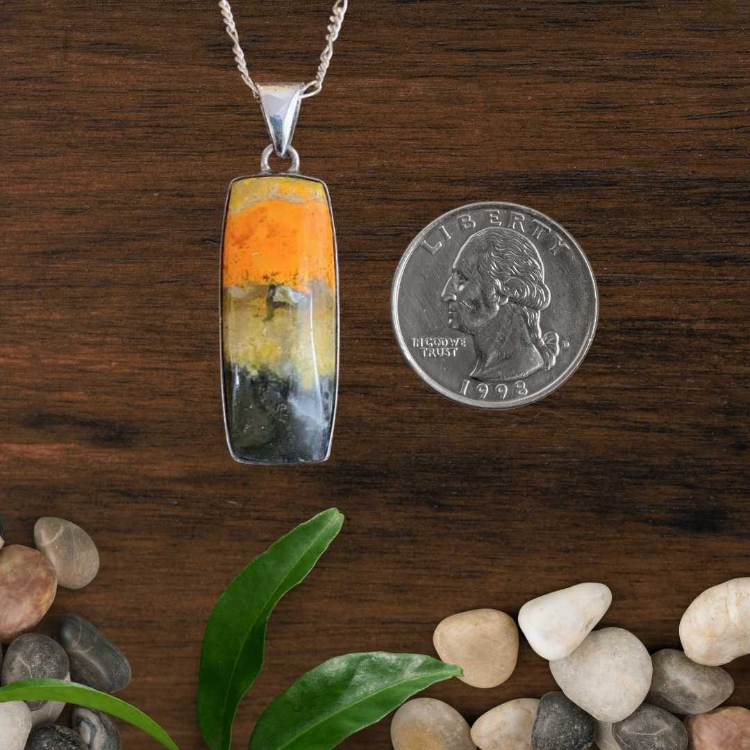 an image of a Narrow Rectangle Bumblebee Jasper and Sterling Silver Pendant next to a quarter