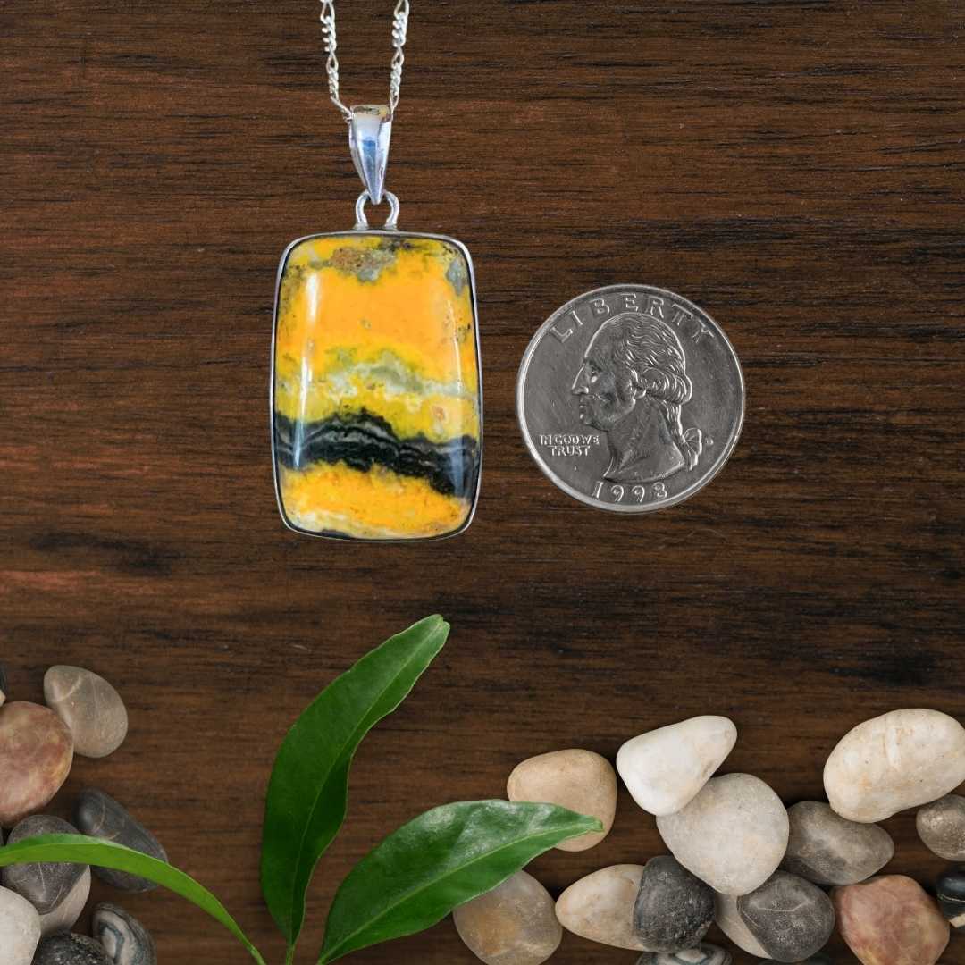 an image of a Rectangular Bumblebee Jasper and Sterling Silver Pendant. next to a quarter