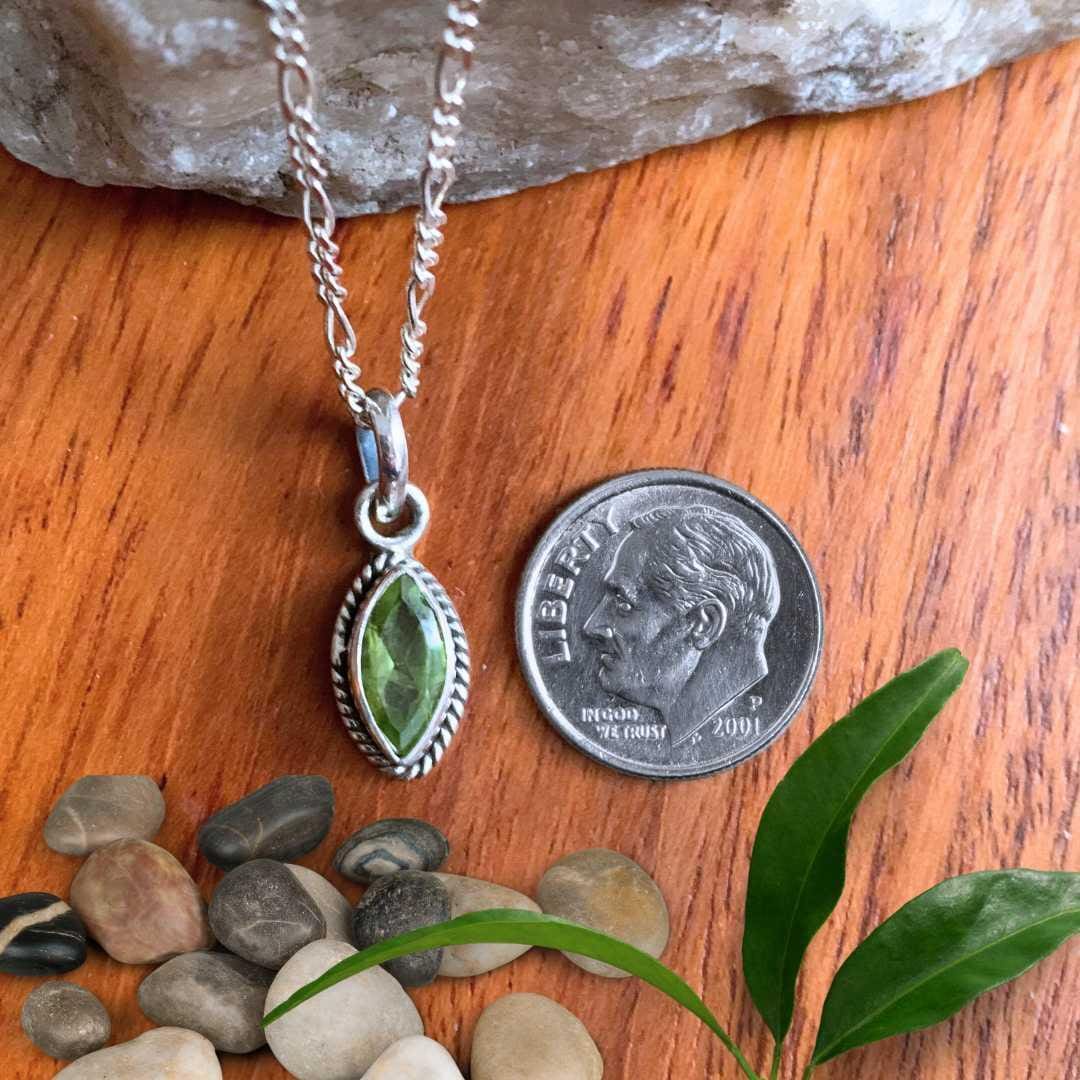 an image of a Petite Marquise Peridot and Sterling Silver Pendant next to a dime