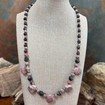 an image of a Rhodochrosite Teardrops and Larvikite Necklace featuring 5 teardrop shaped rhodochrosite beads accented with a mix of faceted grey larvikite beads and rhodochrosite beads offering a lovely combination of the pinks and greys. The necklace is 18.875 inches long.