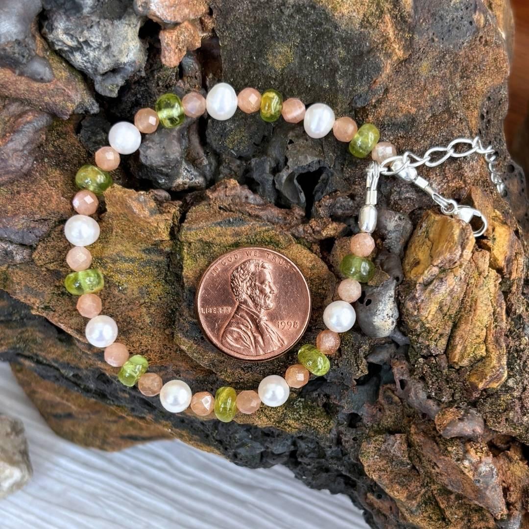 an image of a Pearls with Peach Moonstone and Peridot Bracelet next to a penny