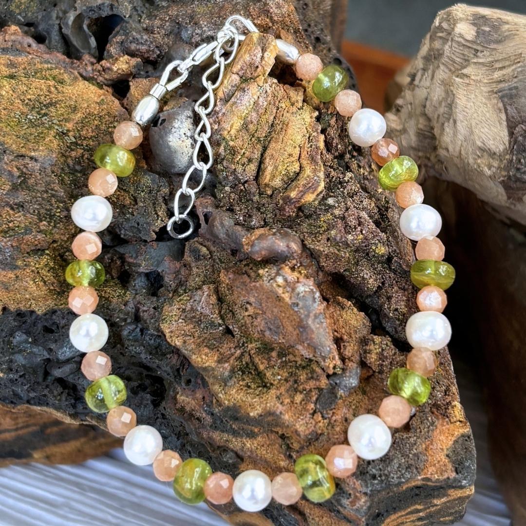 an image of a feminine Pearls with Peach Moonstone and Peridot Bracelet with a sterling silver lobster clasp and 1.5 inch sterling silver extension chain.