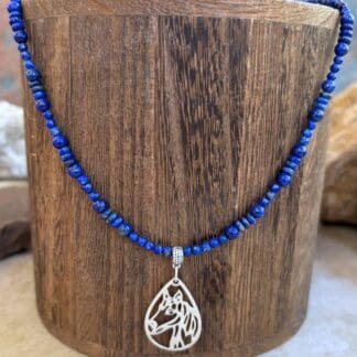 an image of a Lapis Lazuli Beaded Necklace with Horse Pendant featuring two sizes of small round smooth lapis beads with small rondelle beads. The focal point is a silhouette filigree teardrop shaped pendant of a horse's head in sterling silver.